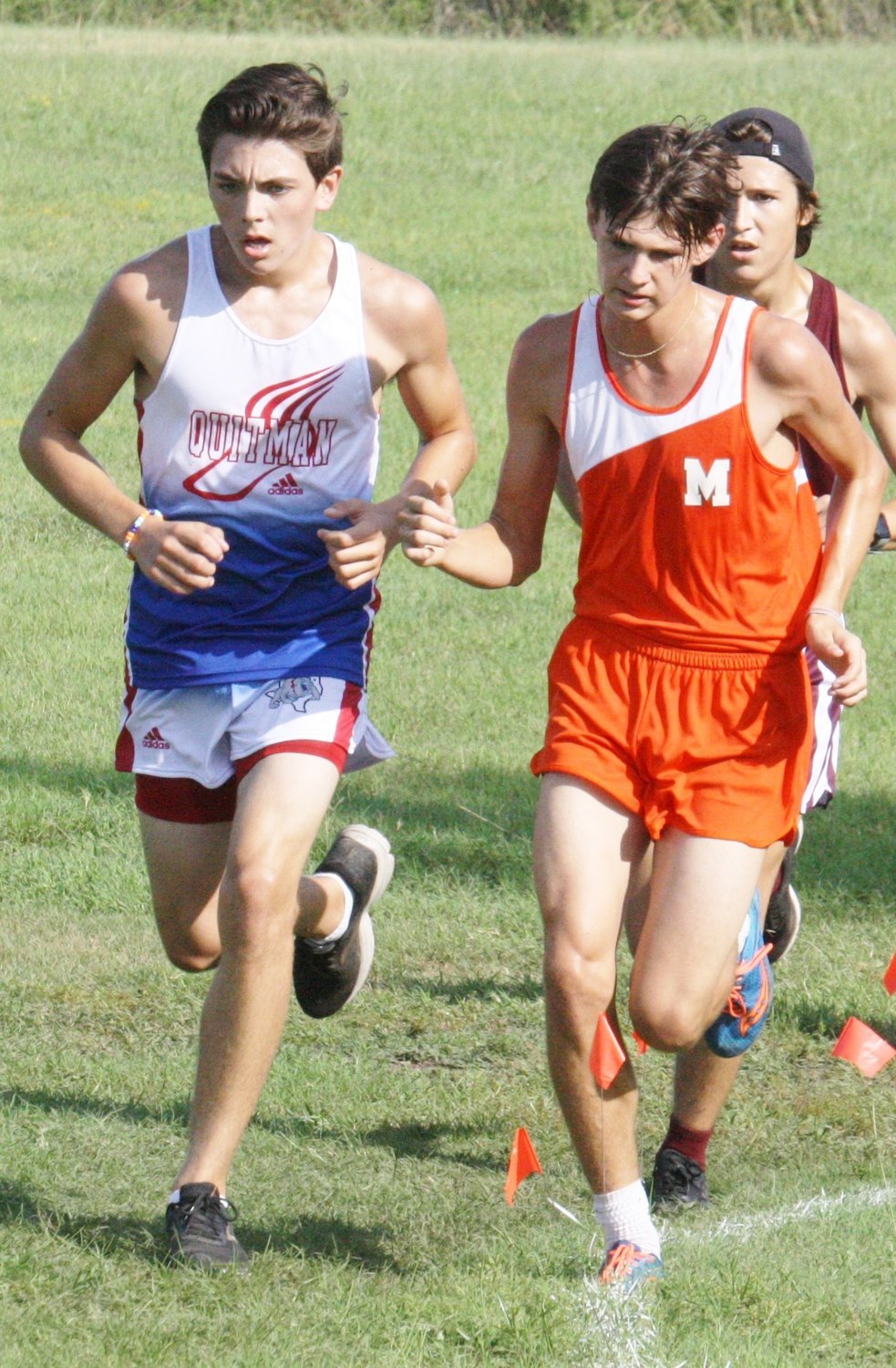 Quitman’s Brandon Jimenez and Mineola’s Dalton Crowson battle around a turn at the Mineola Invitational. Crowson finished 9th and Jimenez 10th in varsity boys competition.