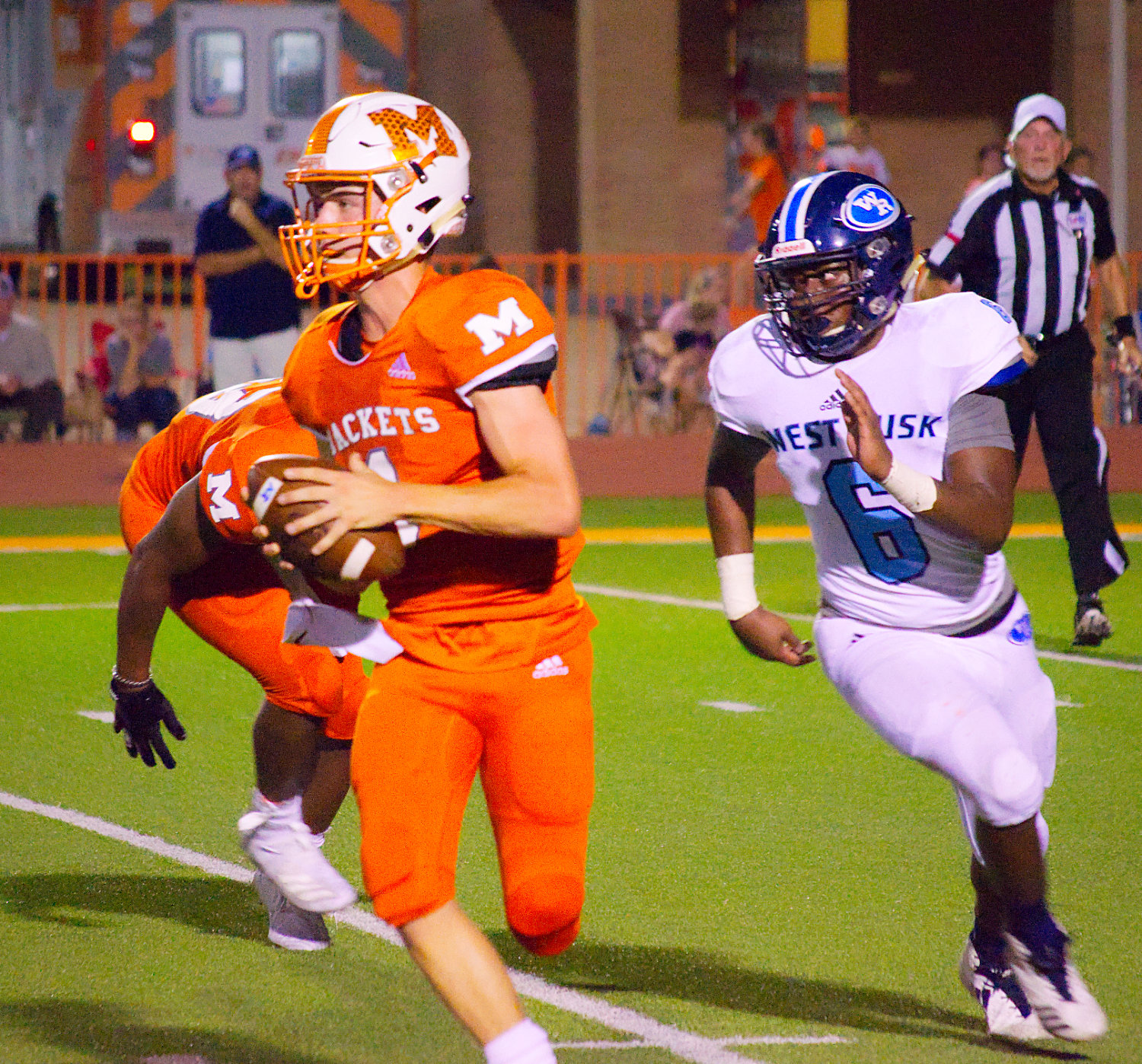 Mineola quarterback Thomas Hooten rolls out on a run-pass option in the Yellowjackets’ district opener with West Rusk Friday night.