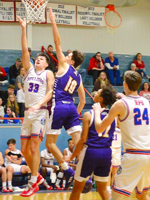 Quitman’s Jace Reid (33) scores on a driving lay-up as Rylie Flanagan (24) looks to rebound.