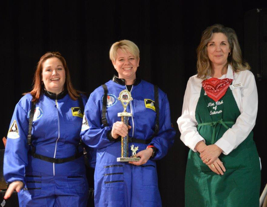 Speakeasy Coffee House representatives (left to right) Brandy Bradshaw and Kelly Keike accept the first place Showmanship Trophy from Paige Eaton at Friday’s Quitman Pilot club Chili cook-Off.