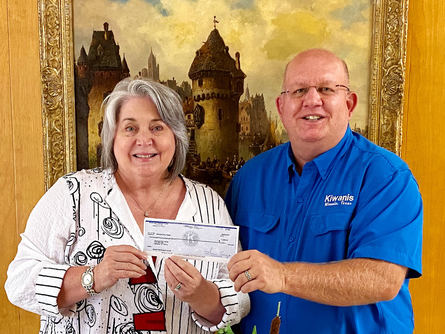 Nancy Murphy, civic center manager, accepts the $1,500 check from Kevin White, Mineola Kiwanis president.