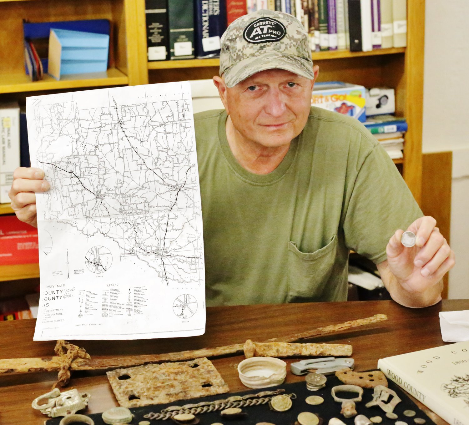 Cottonwood community resident Jerry Tinney displays a 1936 map of the county and the first silver coin he recovered. (Monitor photo by John Arbter)