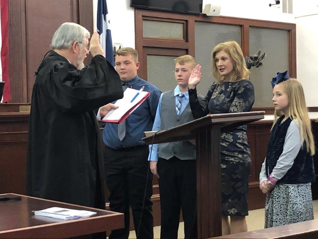 Former District Judge Timothy Boswell swears in Wood County District Attorney Angela Albers as her children (from left) Seth, Tate and Ella Catherine stand by her side.