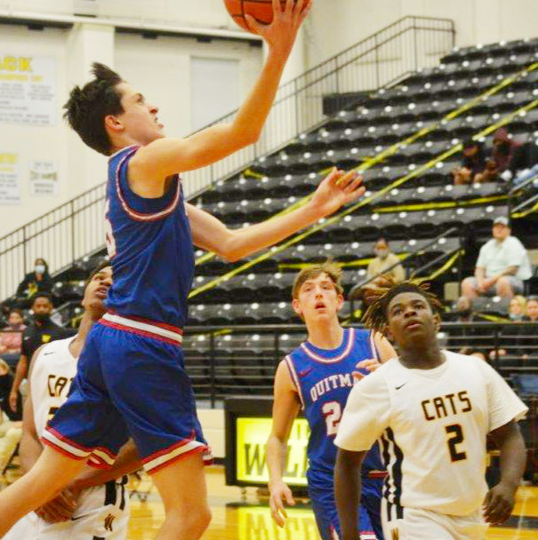 Quitman’s Levi Thompson (5) goes to the bucket for a score in the Bulldogs’ district win at Winona. Thompson had 19 points and hit on 13-16 free throws.