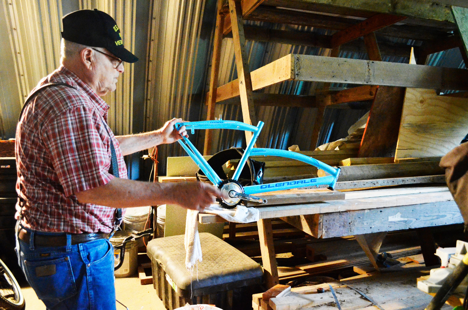 Robert Pierce holds a bike part that he is using to repair other bicycles. The Mineola resident rebuilds older or damaged bikes for those in need.