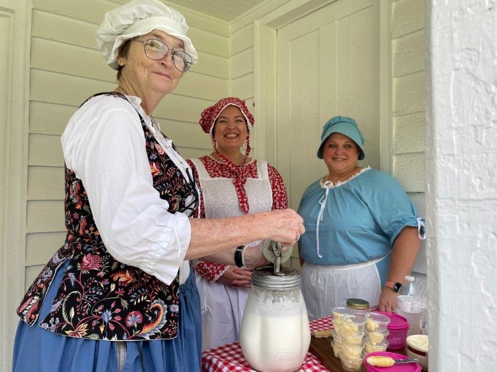 Members of the Elizabeth Denton Chapter in Mineola, above, were on hand at Jim Hogg City Park Sunday to celebrate July 4th. They were in period costume and are shown here churning to make butter the old fashioned way.