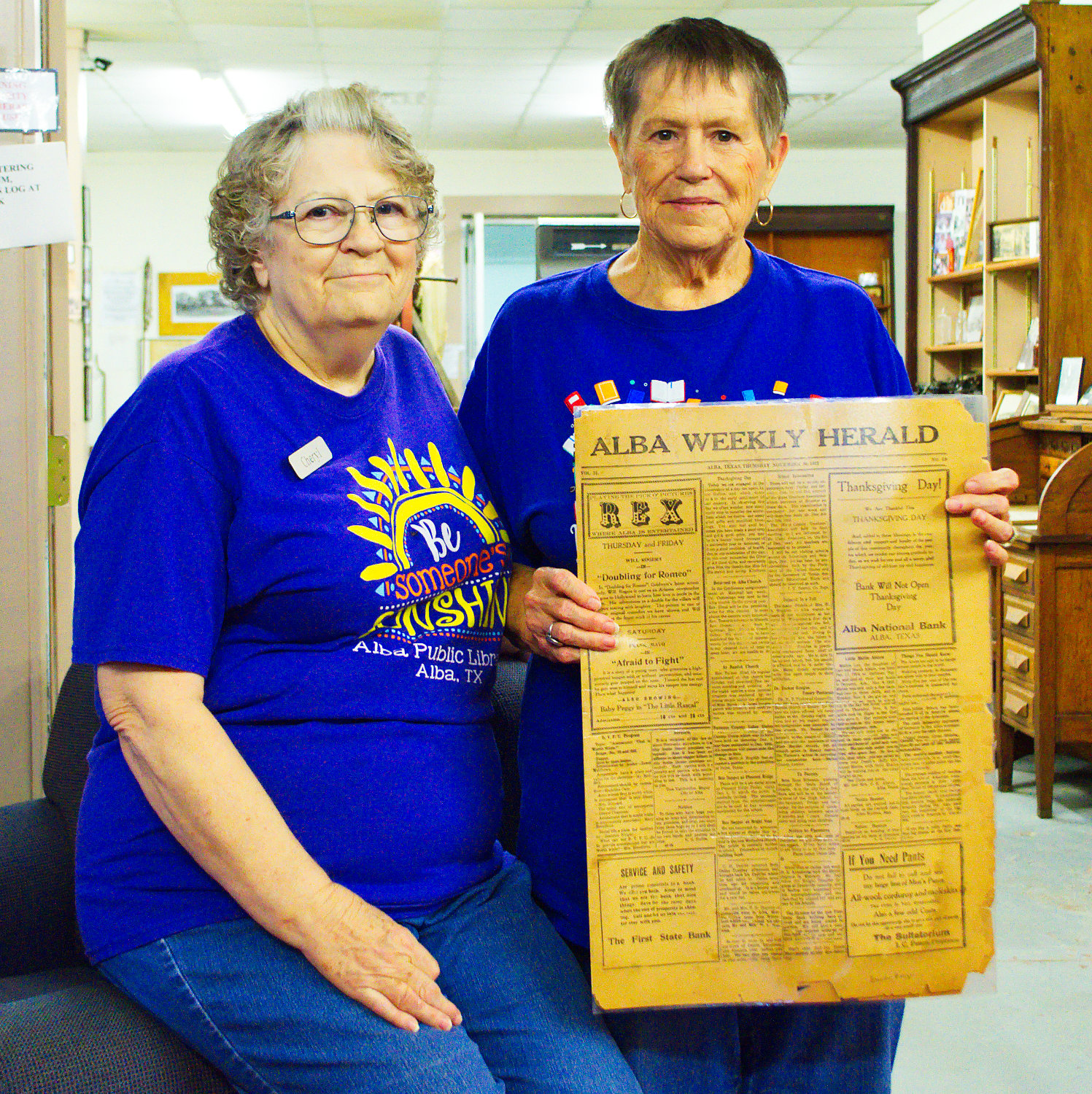 Librarian Cheryl Gill and volunteer Saundra Burge show off an old Alba Weekly Herald from the library/museum’s collection.