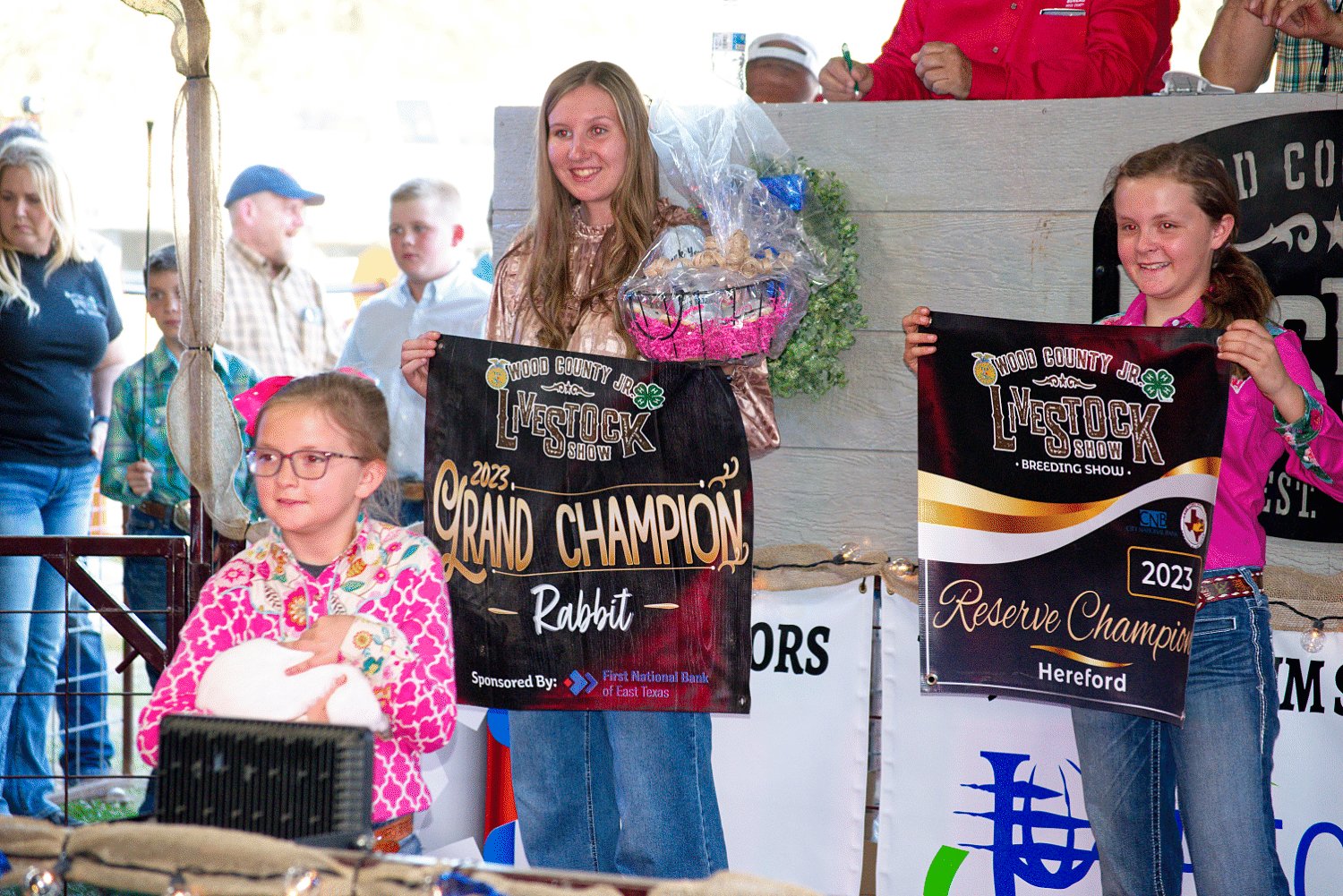 Kyleigh Swanner of Winnsboro shows of her grand champion rabbit during the junior livestock show auction.