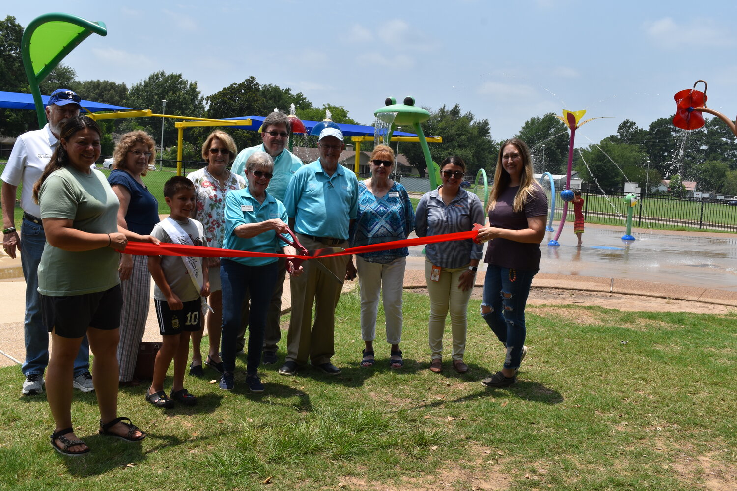 Though it’s been open for awhile, the Mineola Kiwanis Club held the official opening for the splash pad at the Mineola Civic Center Tuesday. The planned event had to be delayed due to weather on Memorial Day weekend. The club recently helped complete the project to add shade sails to the splash pad, so that parents and others would have a shady place to sit near the pad. The club also passed out free popsicles at the event.