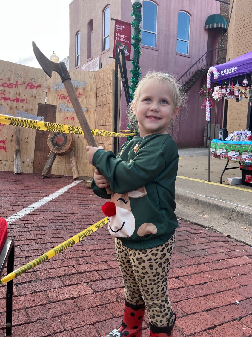 Madisyn poses at the axe throwing booth.