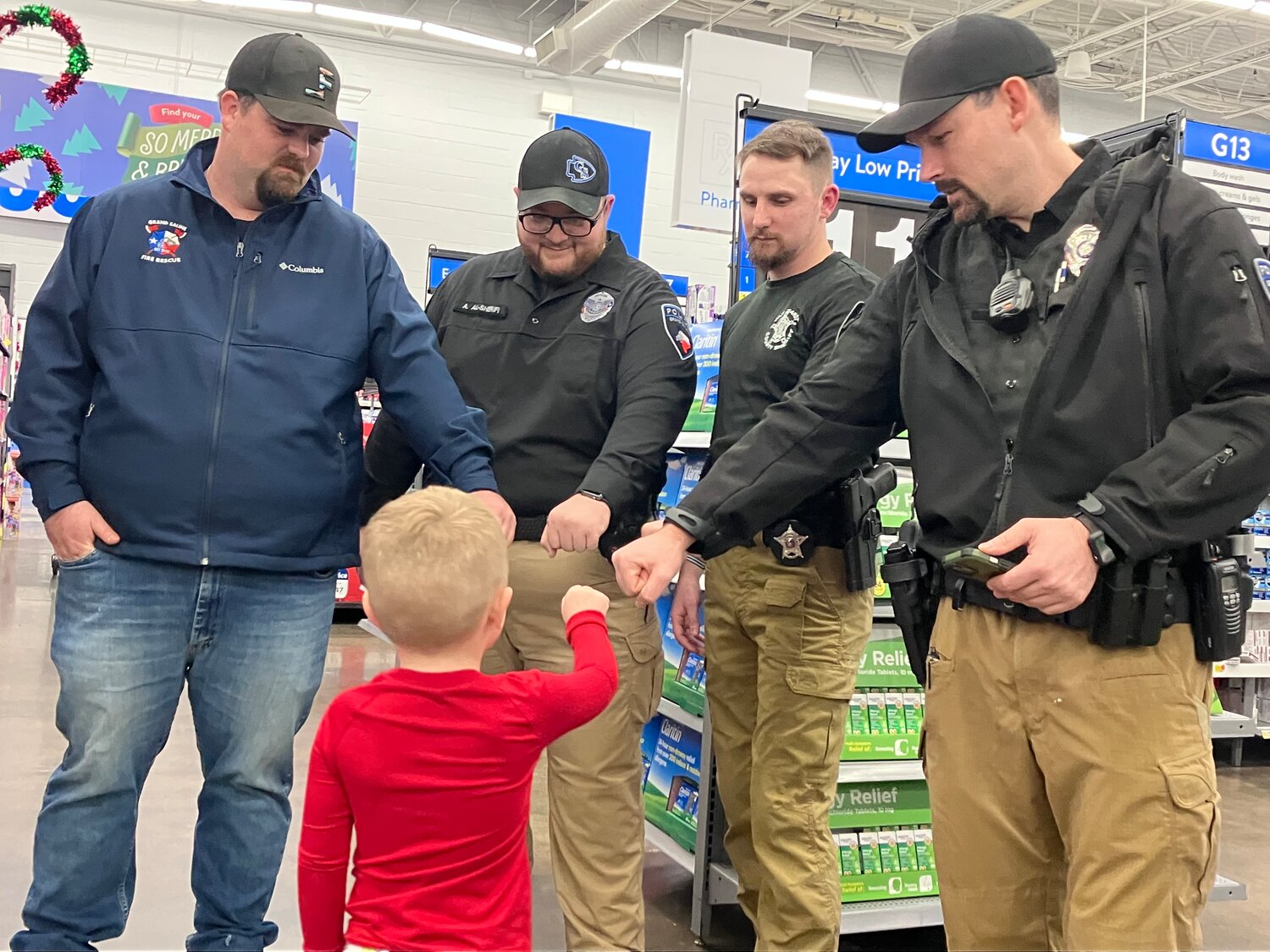 Connor fist bumps the officers helping him shop during last Tuesday’s Blue Santa at Walmart in Mineola.