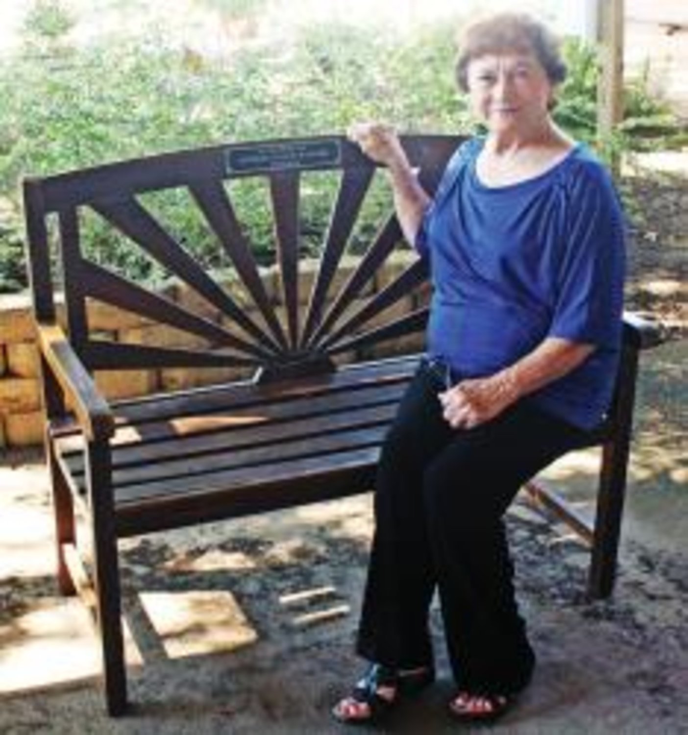 Mary Ballard, wife of the late Delbert Ballard and former Quitman ISD coach and teacher, sits on the bench dedicated to her husband's legacy.