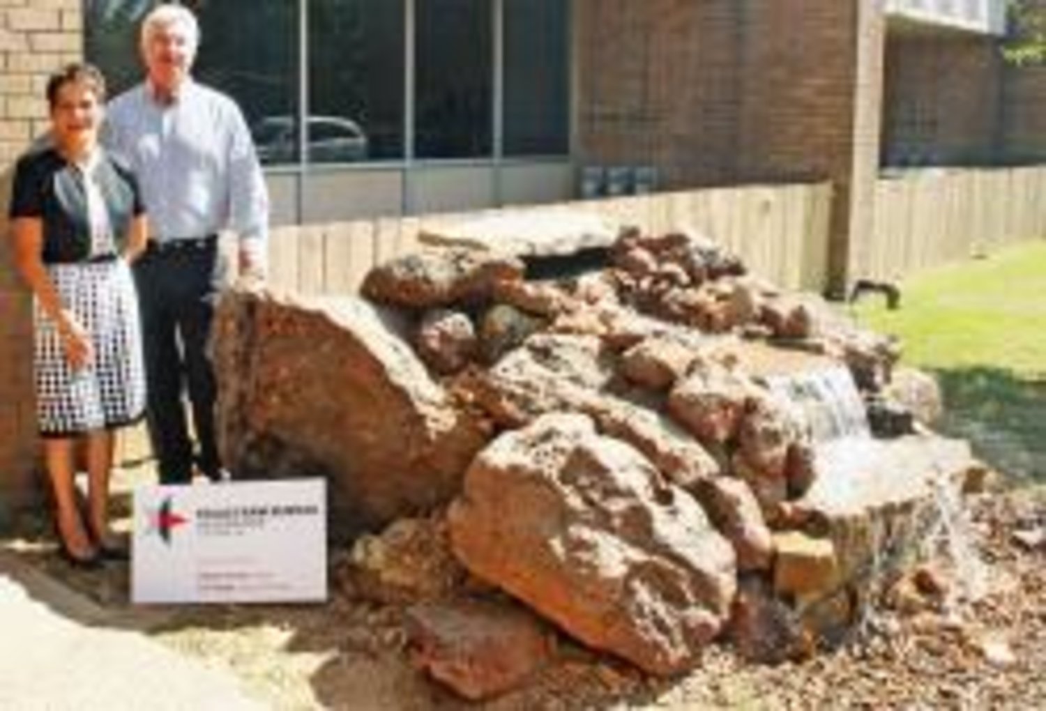 Debbie Skinner (left) and Tim Yeager (right) of Texas Farm Bureau Insurance stand next to the fountain they donated to Quitman Junior High School. The fountain was designed by Erica Fry.