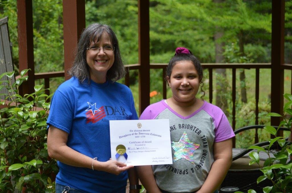 Quitman student Atlana Watkins receives recognition from Shelly Chance, who represents the Robert Dibble Chapter of the Daughters of the American Colonists for her U.S. Postal Stamp design. Chance is the group’s historian.