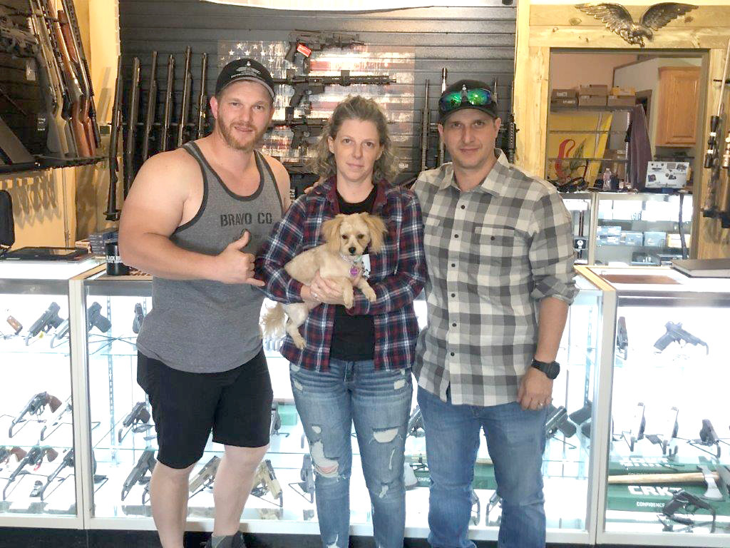 Owners of Minuteman Ordnance Company are pictured in the store, from left, David Gonyea, Stephanie Gonyea and Mike Gonyea. Stephanie is holding the store canine protector, Mayflower.