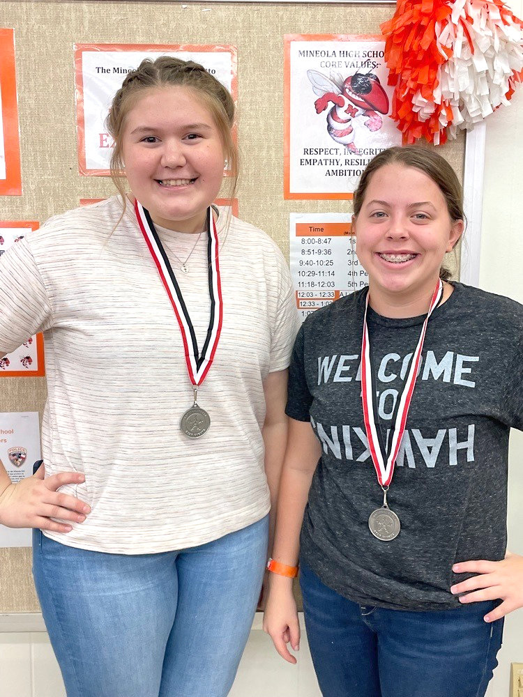 Mineola High School students Sydney Van Cleave, left, and Zoe Goodson show off the silver medals they won in the Family, Career and Community Leaders of America national leadership conference for their entry to promote and publicize the organization. They were recognized at Monday’s school board meeting