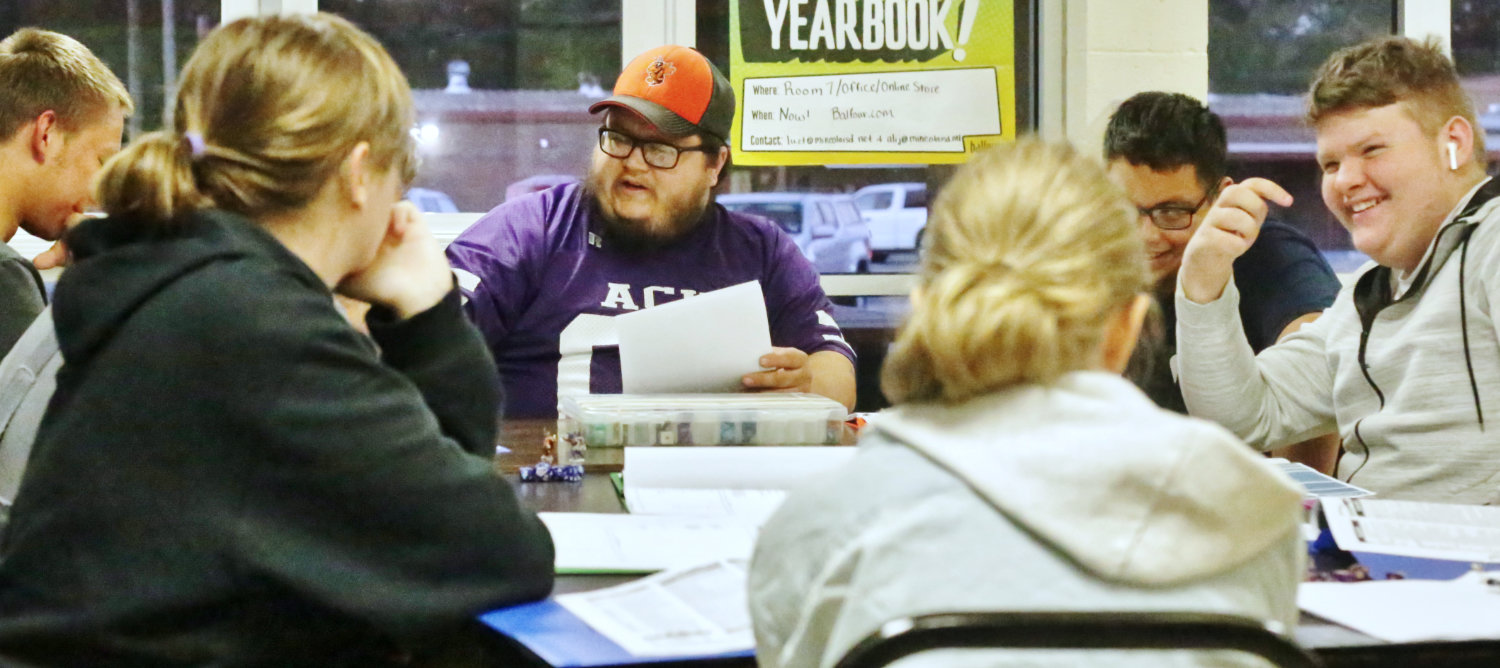 Graphic Art teacher Aaron Cavitt, shown (in ballcap) facilitating a game, led the initiative in creating the gaming club.