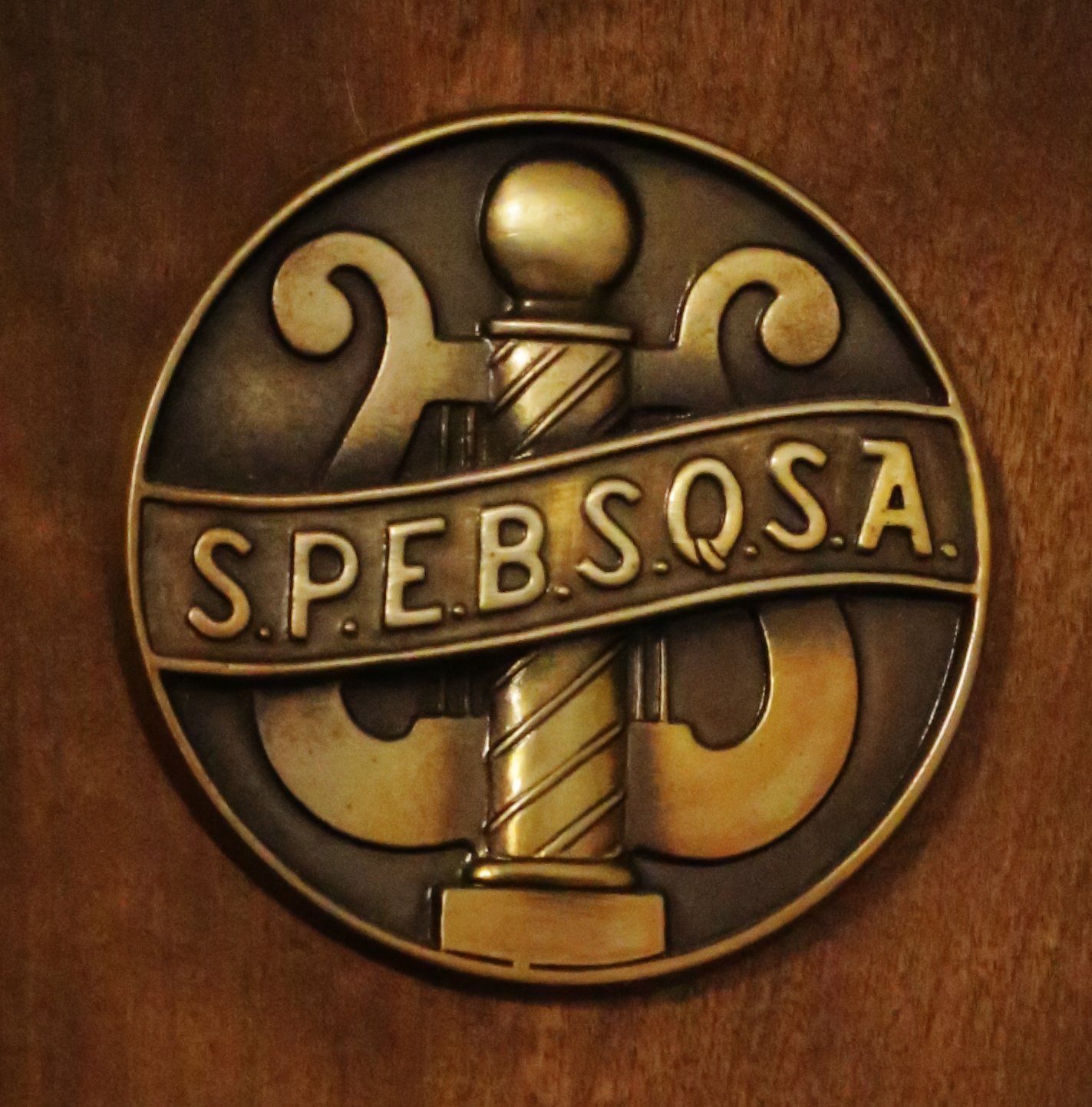 Crest of the Society for the Preservation and Encouragement of Barber Shop Quartet Singing in America (SPEBSQSA).