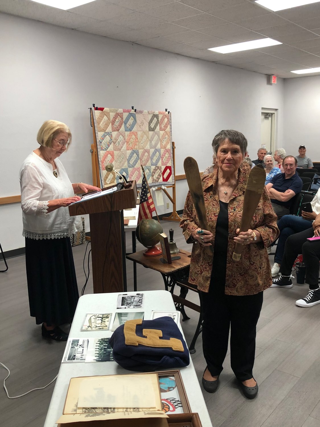 Commissioner Ulna McWhorter shares stories and Saundra Burge displays a girls’ paddle and a boys’ paddle from early Alba. The White family displayed several items including J.U. Searcy’s cane and satchel.