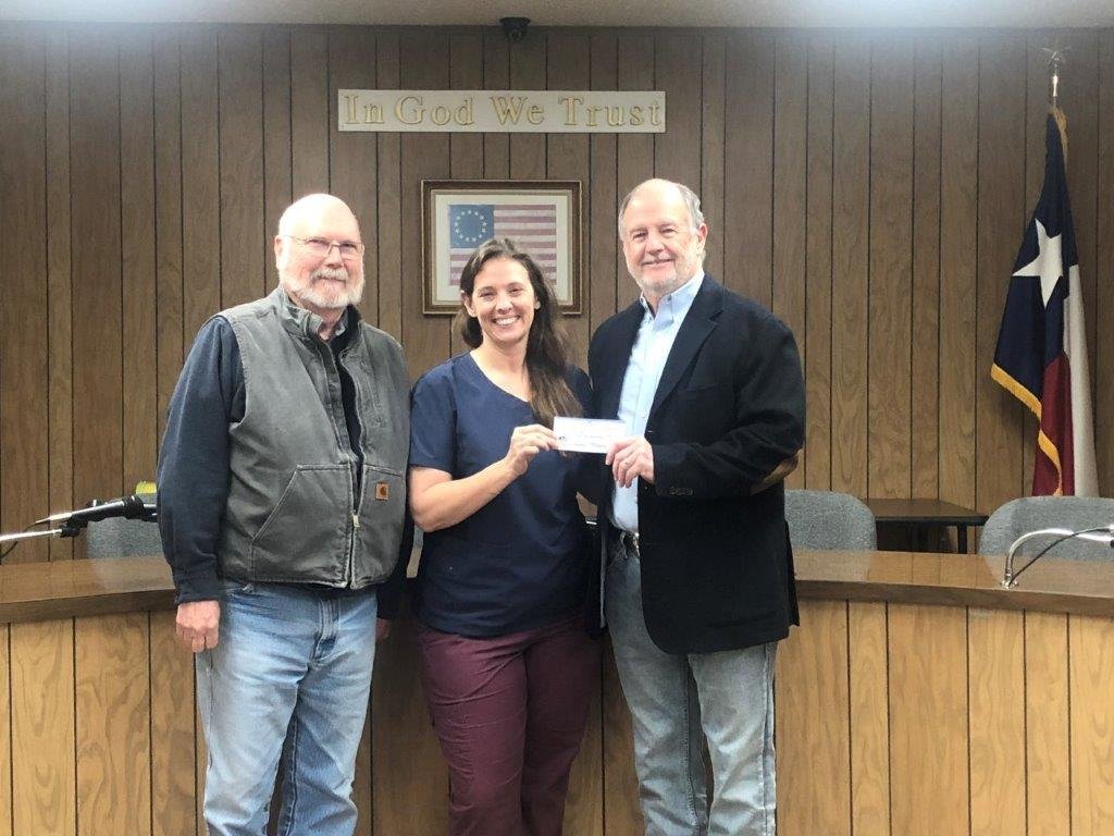 Quitman Mayor Randy Dunn, right, accepts a $75,000 check from Dr. Joanne Wisdom and J.R. Evans of the Quitman Lake Country Charitable Foundation to go toward rebuilding the pavilion at Jim Hogg City Park.