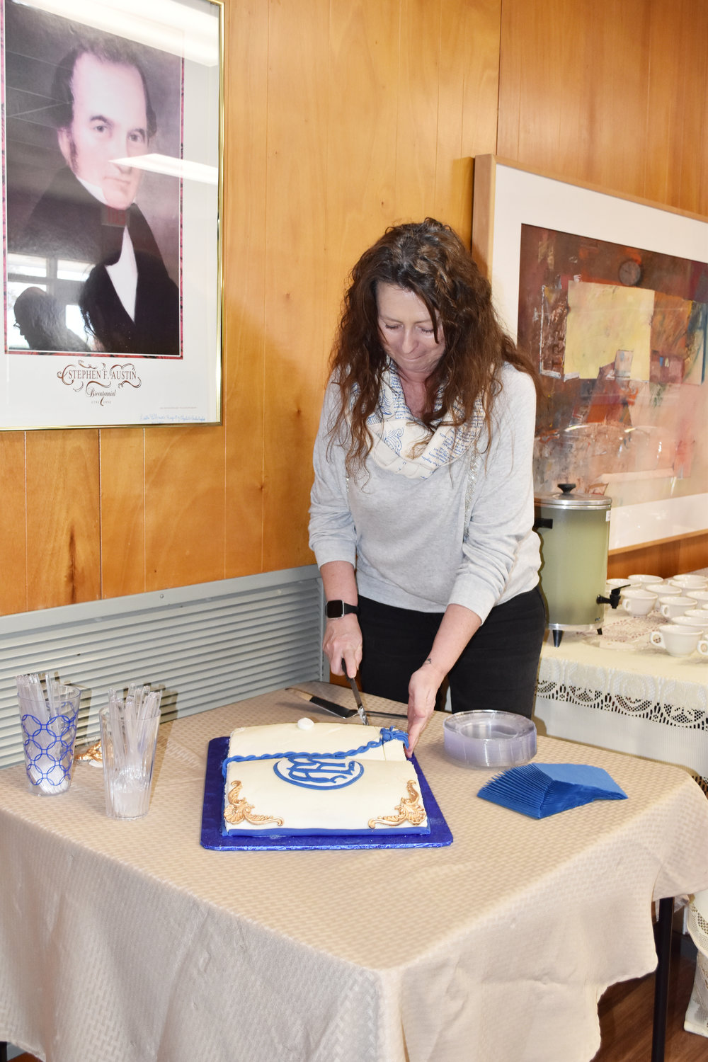 Pam Hortman does the honors cutting the anniversary cake for the Mineola Memorial Library at Saturday’s celebration of 63 years at its present location.