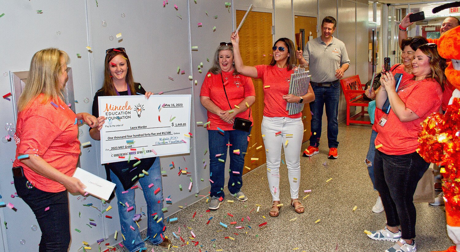Mineola High School teacher Laura Marder gets a confetti shower as she is awarded a teacher grant from the Mineola ISD Education Foundation during the annual prize patrol Friday.