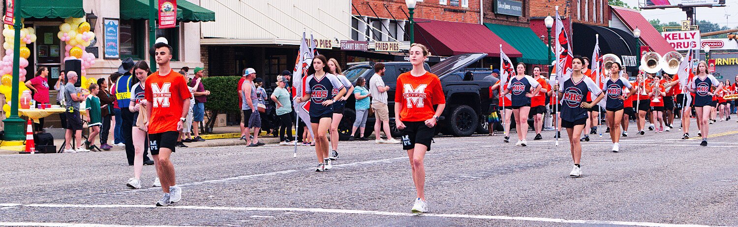 The Sound of the Swarm marching band is led by senior drum majors Cameron Bussell and Maddie Tucker through downtown Mineola one last time. [see so many more sesquicentennial spring fling photos]